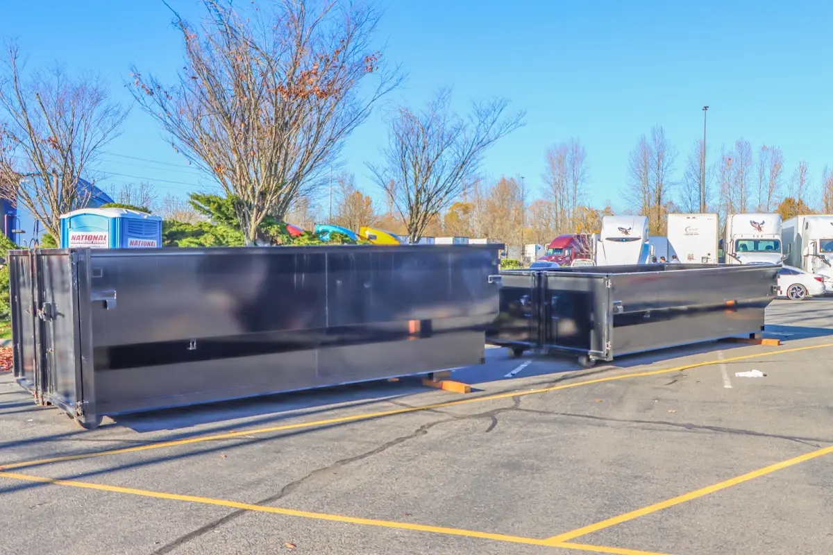 Professional dumpster rental service with roll-off container on residential driveway in Fairview